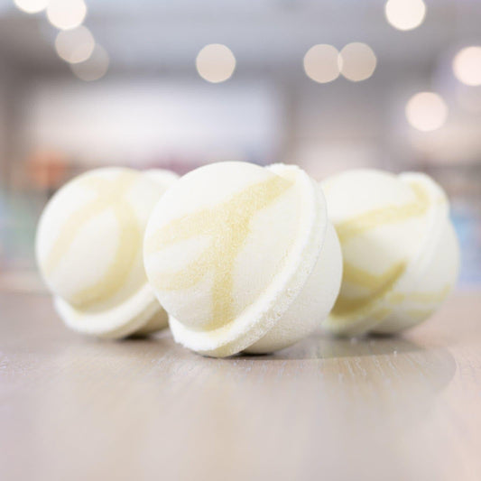 Three Good Morning Sunshine Bath Bombs with light yellow design lined up on counter